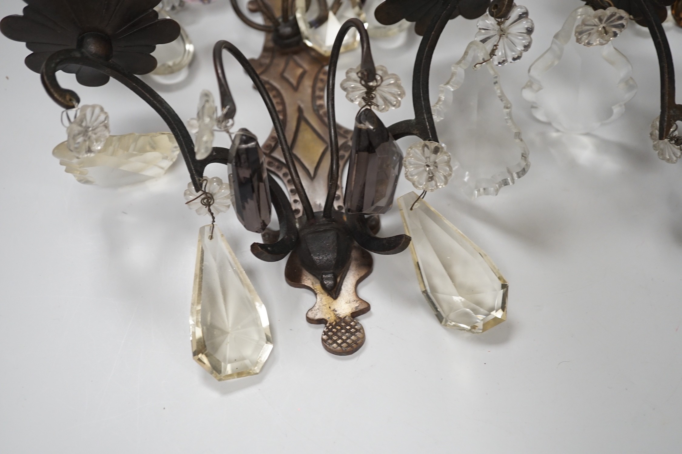 A pair of bronze or brass two branch wall sconces with cut glass drops